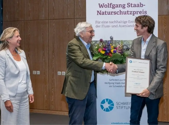 Dr. Niels Kohlschütter schüttelt die Hand von Prof. Dr. Friedrich Schiemer und überreicht ihm die Urkunde.