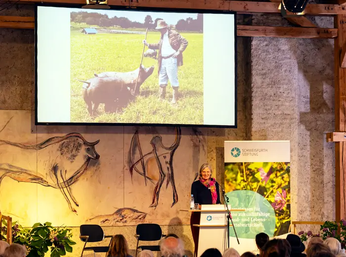 Anne Schweisfurth auf der Jubiläumsfeier. Im Hintergrund ein Bild ihres Vaters Karl Ludwig Schweisfurth.